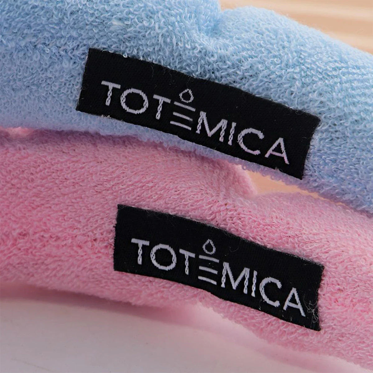 Adjustable spa headbands with TOTEMICA brand tags, blue and pink terry knit