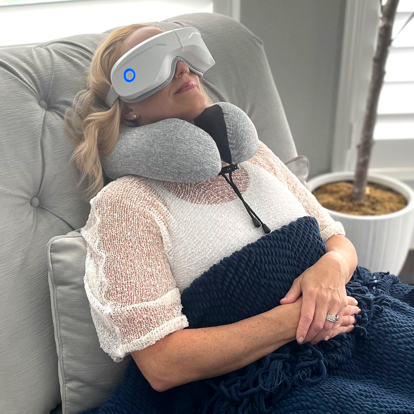 Gray memory foam travel pillow around neck with securing strap, supportive collar shape