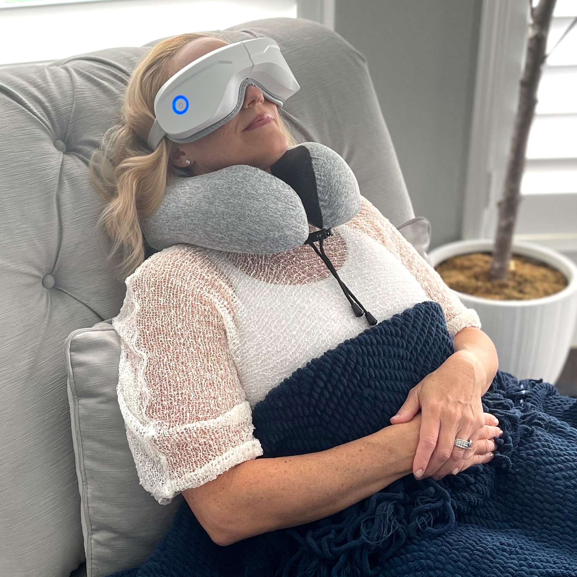 Gray memory foam travel pillow around neck with securing strap, supportive collar shape