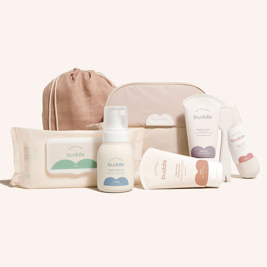 Diaper skincare kit with beige toiletry bag, cleanser pump, rash cream, wipes, and bottles