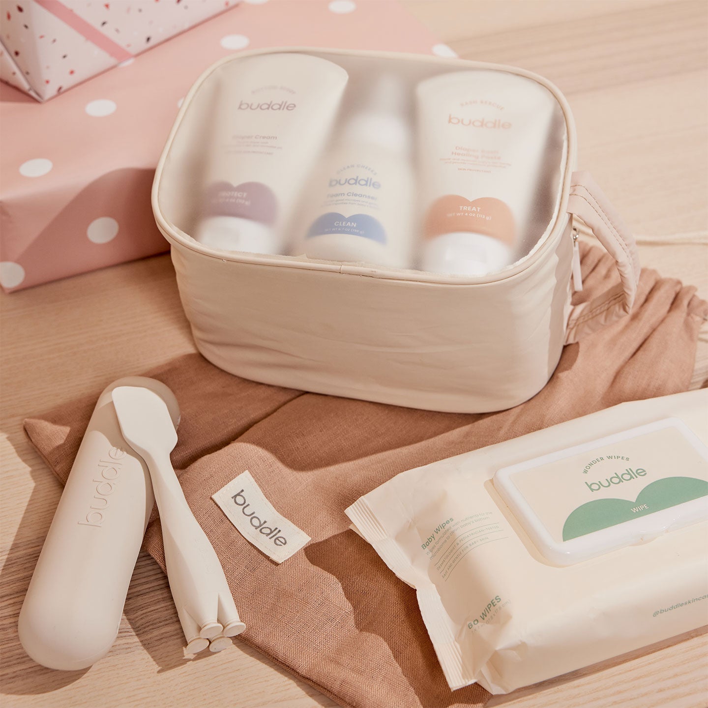 Diaper skincare kit with open toiletry pouch, pump bottles, wipes packs, and soft brush