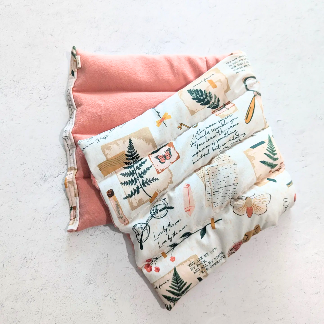 Weighted heating pad with Field Diary print panel over pink flannel lining