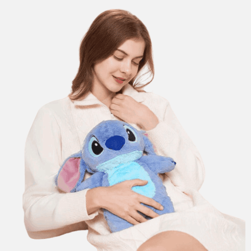Blue plush cartoon hot water bottle hugged by person, face and ears visible