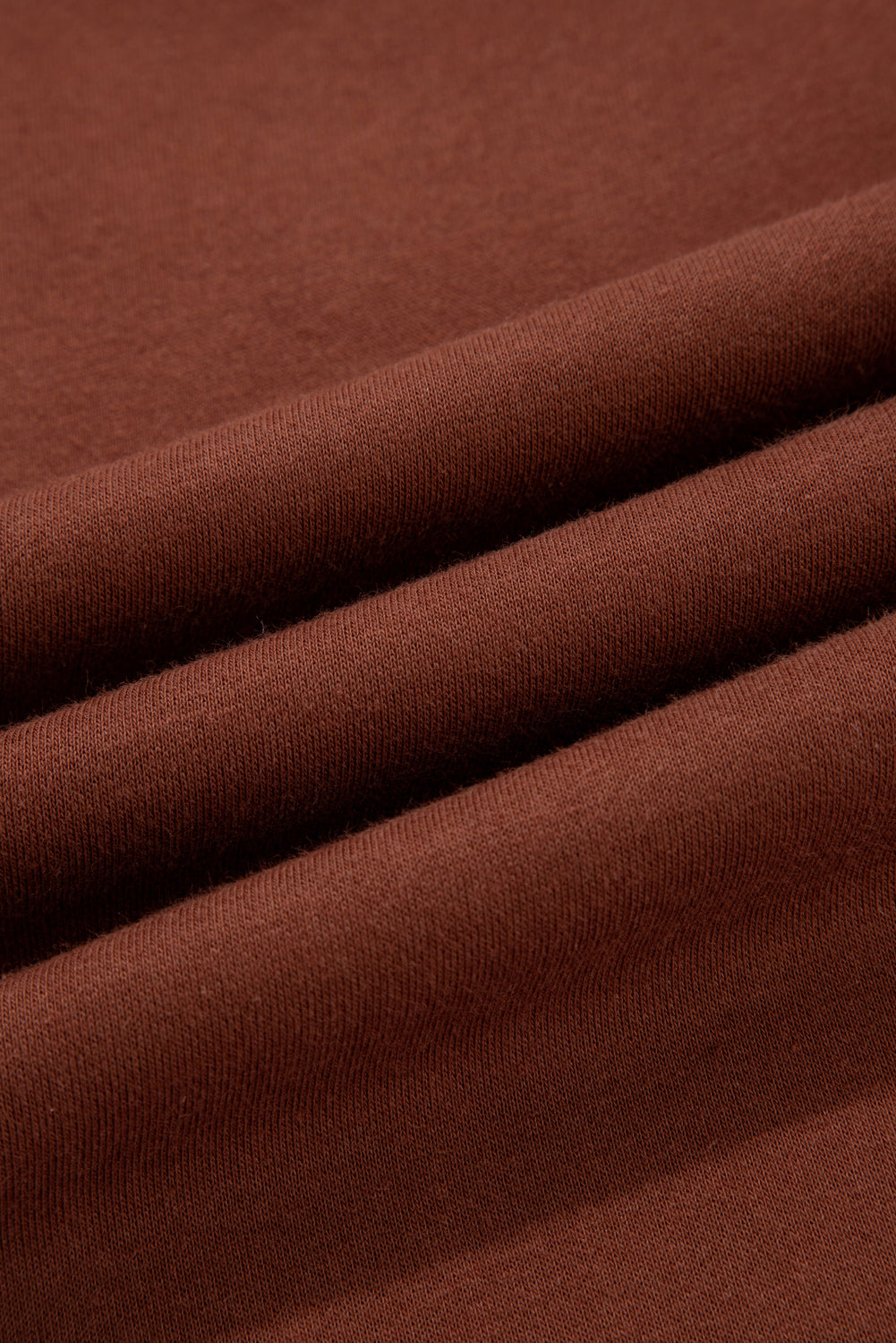 Coffee-brown knit fabric texture detail on solid pants