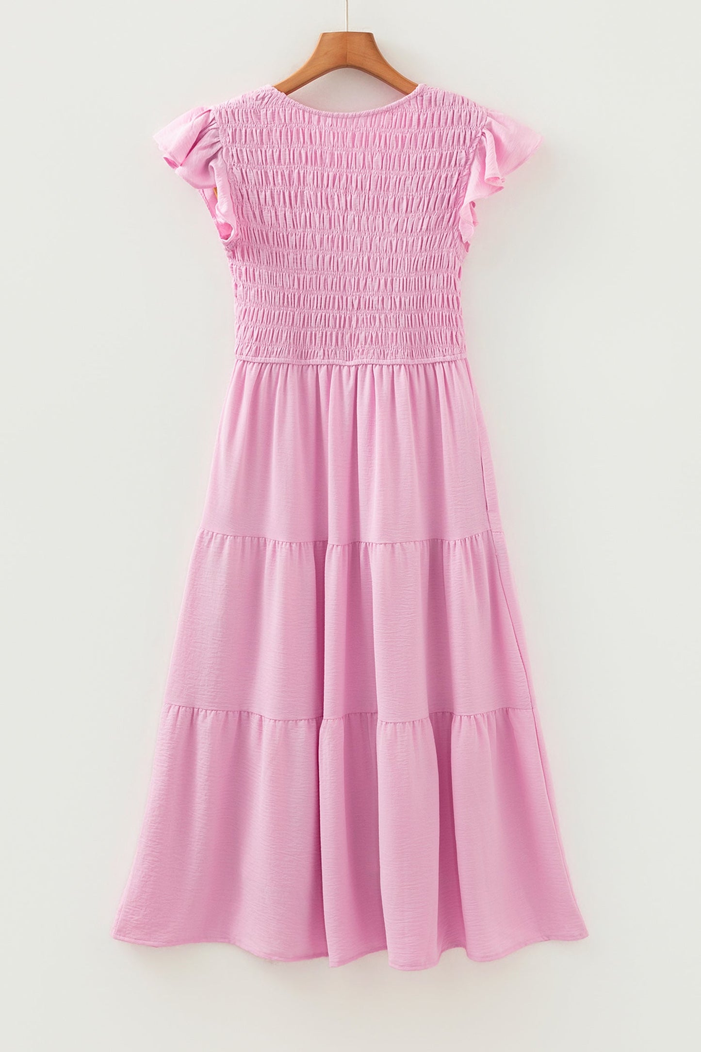 Pink tiered midi dress on hanger with flutter cap sleeves and layered skirt