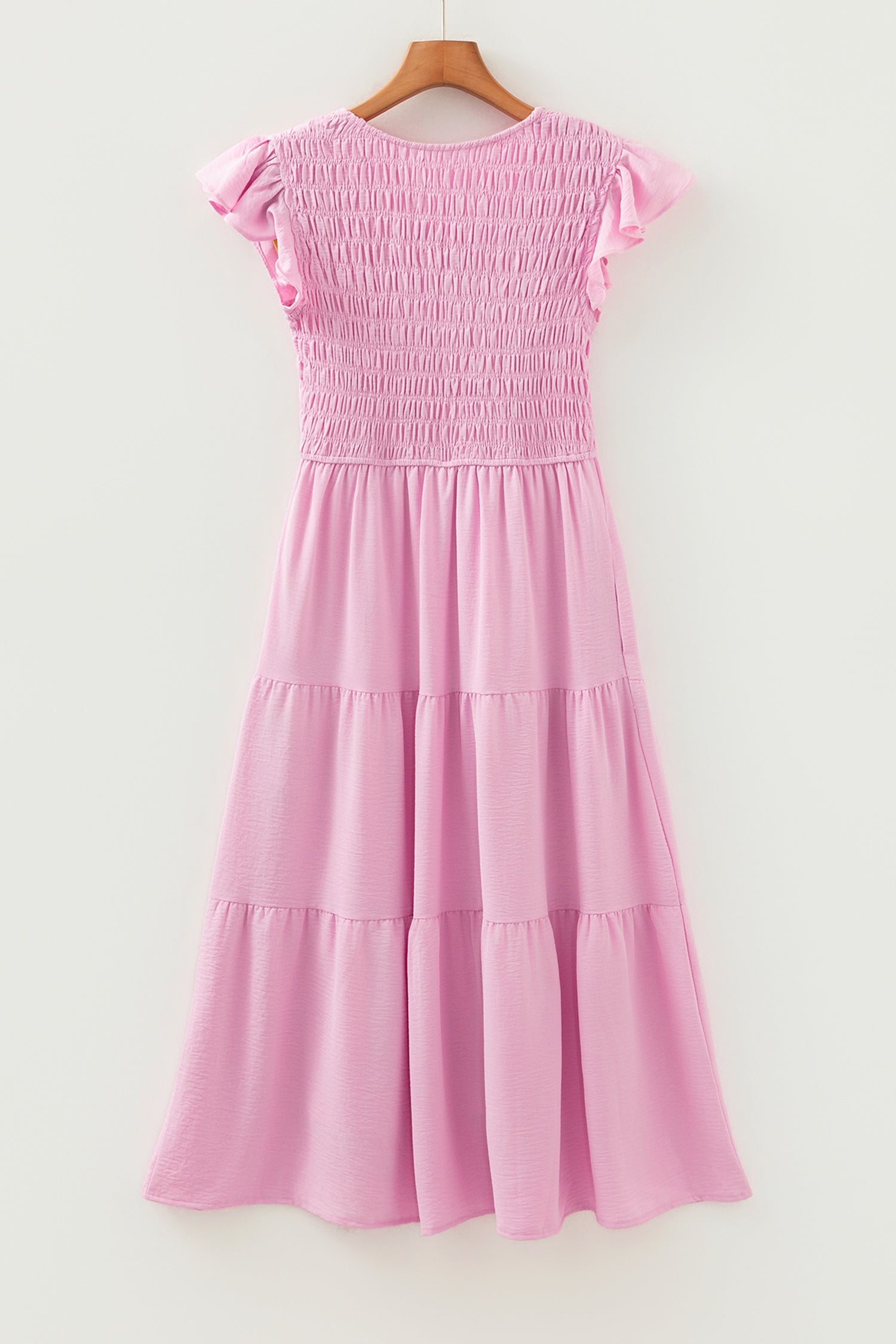Pink tiered midi dress on hanger with flutter cap sleeves and layered skirt