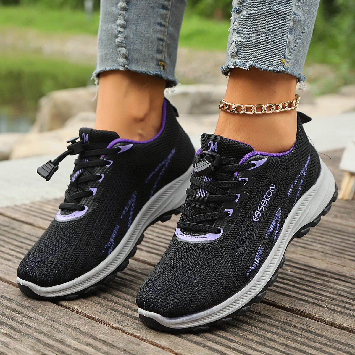Black knit lace-up travel running shoes with purple trim and cushioned sole