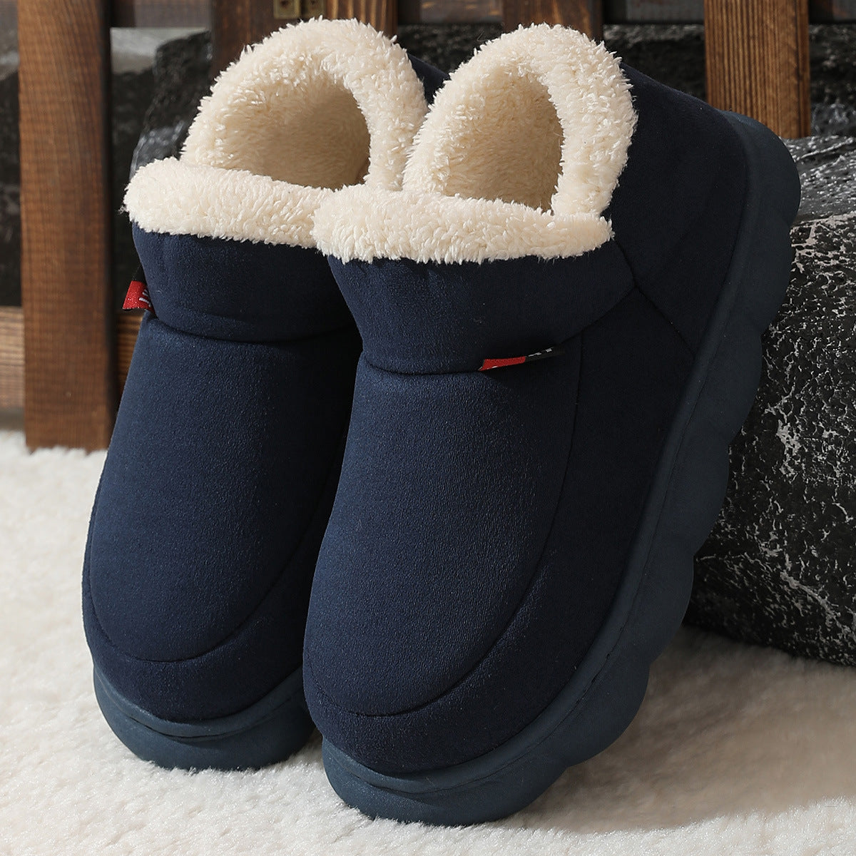 Navy blue plush house shoes with fuzzy strap and thick white sole, back view