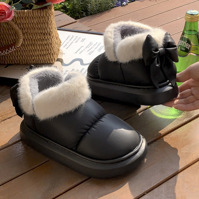 Black winter ankle boots with faux fur cuff, ribbon bow, and thick rubber sole