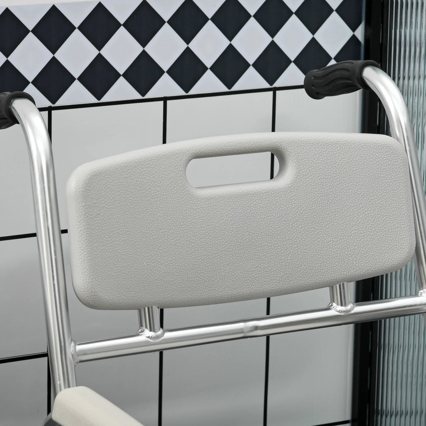 Close-up of textured padded backrest on shower commode wheelchair with black handles