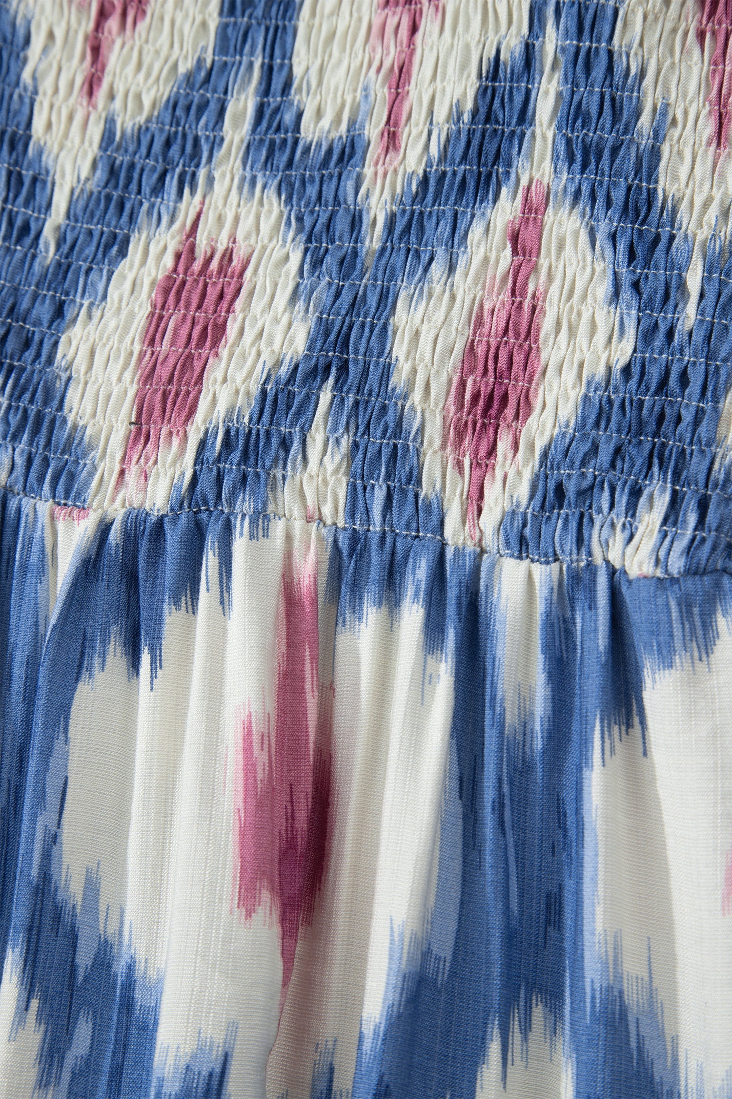 Sky-blue dress with pink abstract print and elastic smocked bodice, ruffle sleeves.