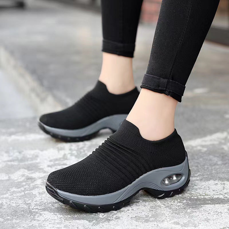 Black knit slip-on sneakers with gray sole and visible air-cushion window