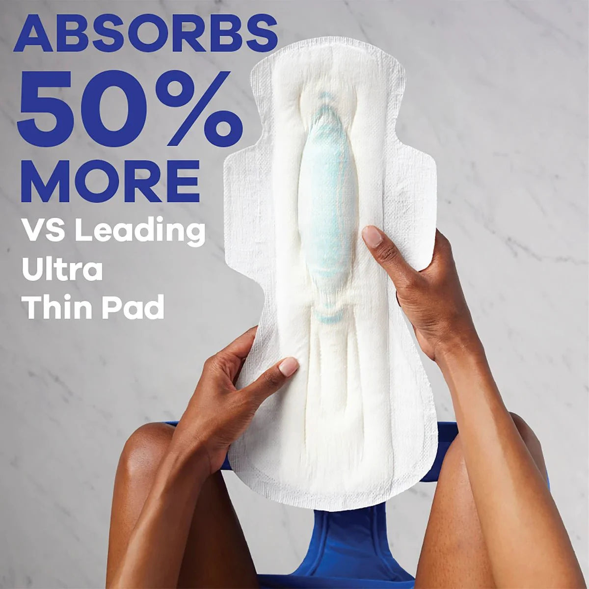Absorbent white overnight pad with wings held in hands; extra heavy overnight comfort