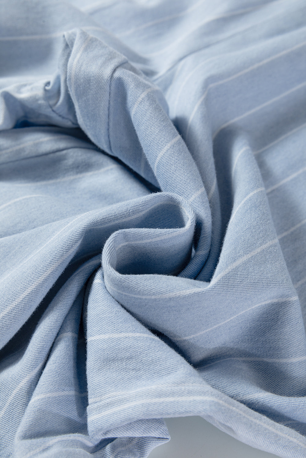 Sky blue stripe woven fabric with soft folds and subtle texture