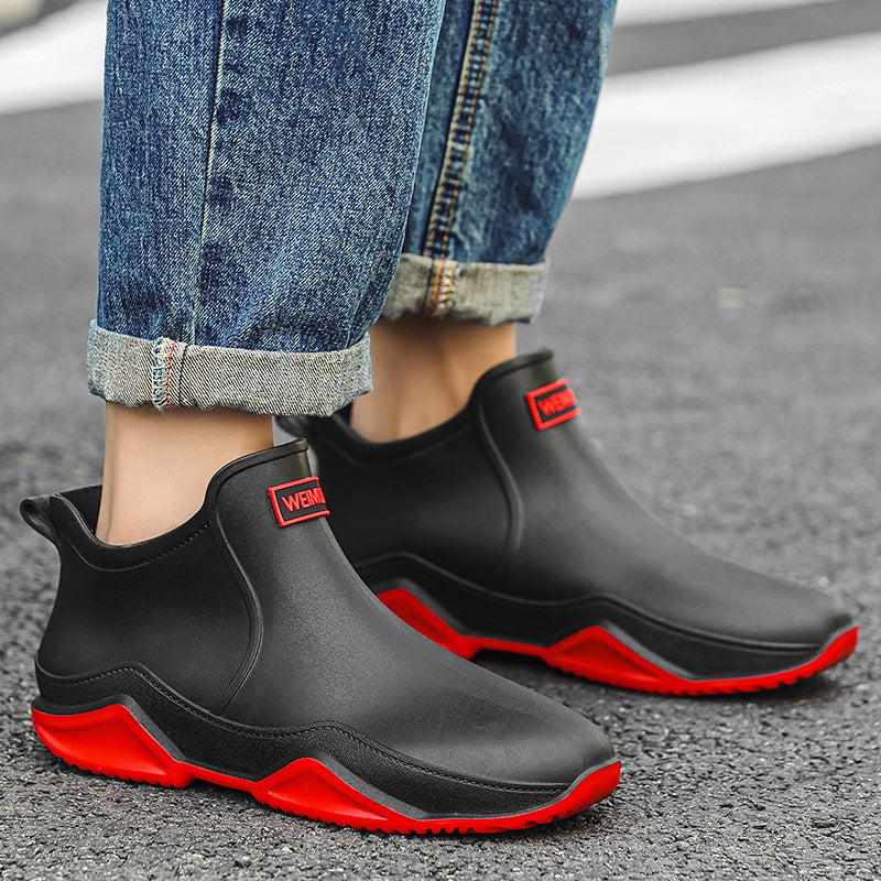 Men's short rain boots in black with red accents, front view with logo patch