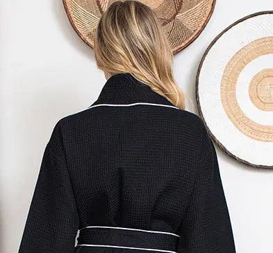 Women’s waffle bathrobe with white piping, black textured robe with belt tie.