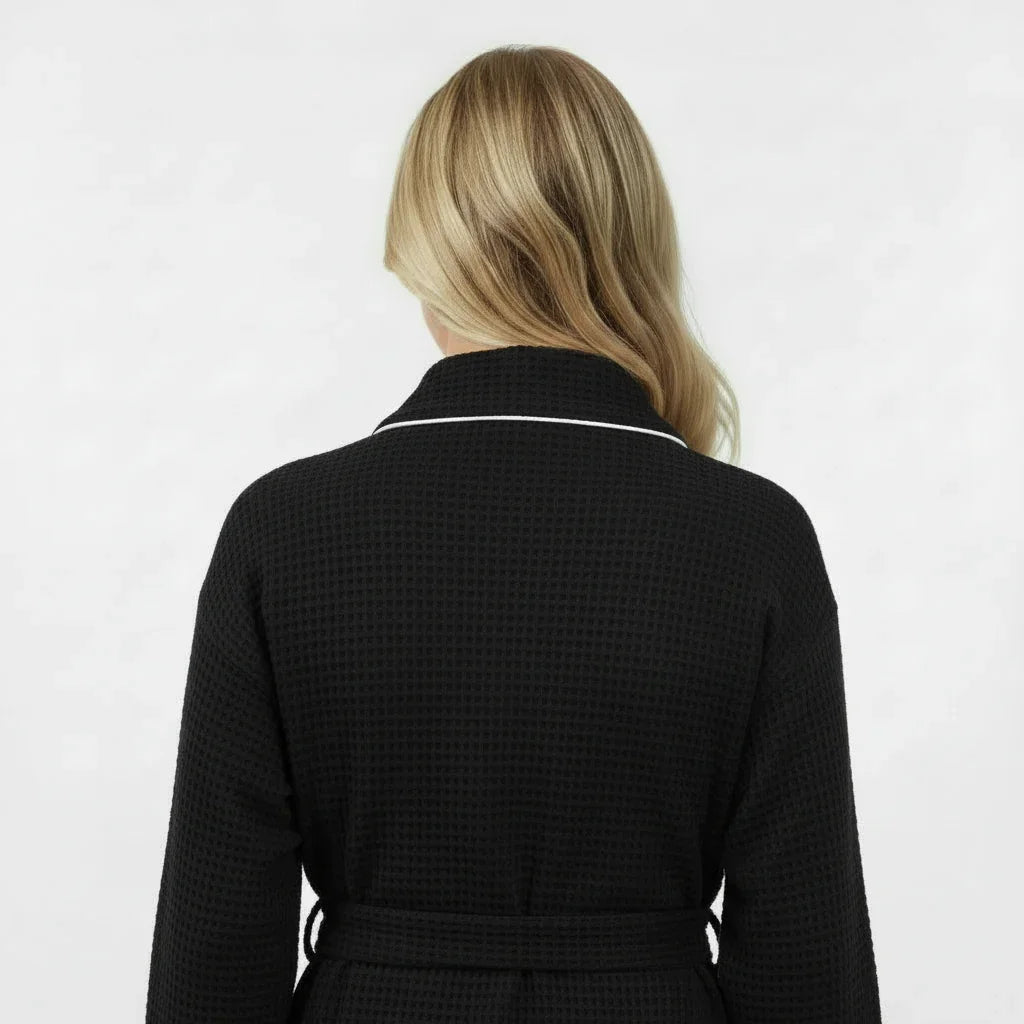 Women’s knee-length waffle robe in black, back view with tie belt and textured waffle knit.