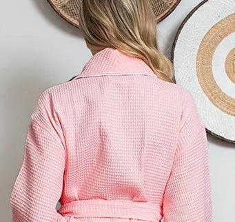 Women’s waffle bathrobe with white piping, blush-pink back view with belt tie.