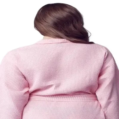 Women’s knee-length waffle robe in blush pink, back view with tie belt at waist.