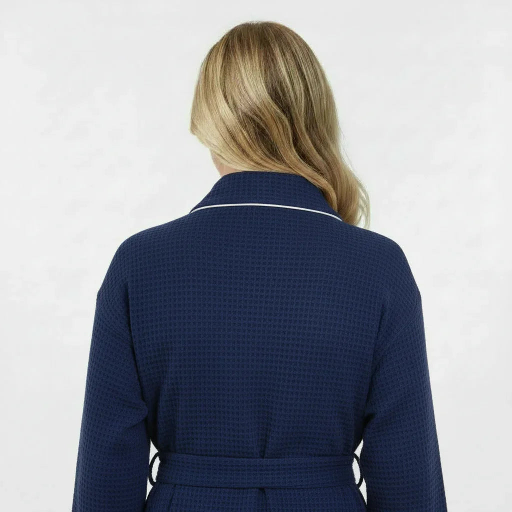 Women’s knee-length waffle robe in navy, back view with tie belt and contrast piping.