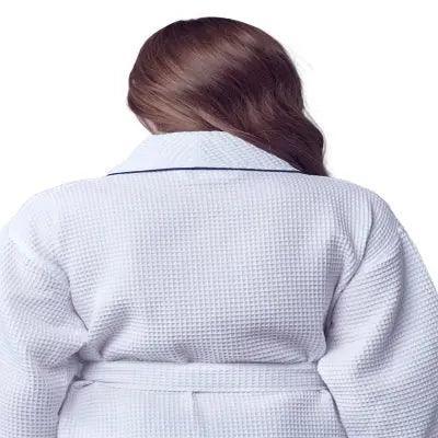 Women’s waffle bathrobe in white with light piping and tie belt, rear view.