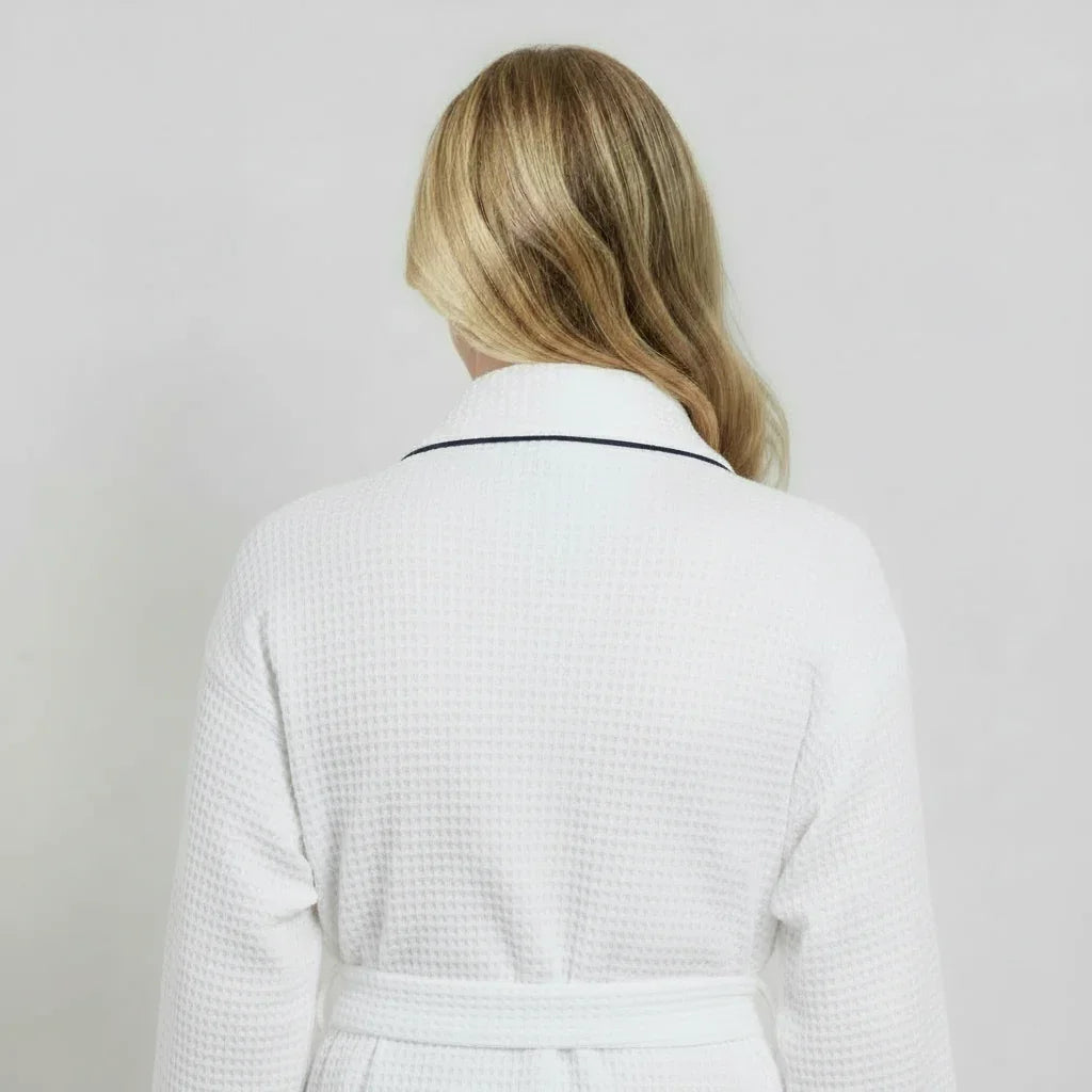 Women’s knee-length waffle robe in white, back view with tie belt and contrast-trim collar.