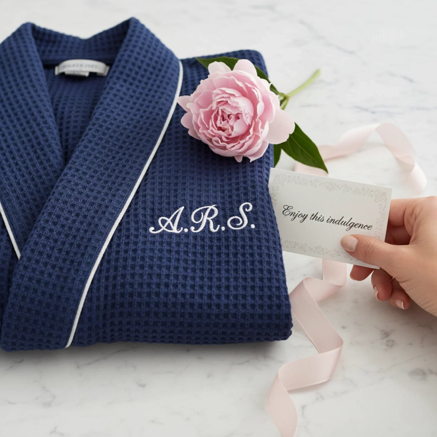 Women’s waffle bathrobe with white piping, navy folded robe with V-neck and belt.