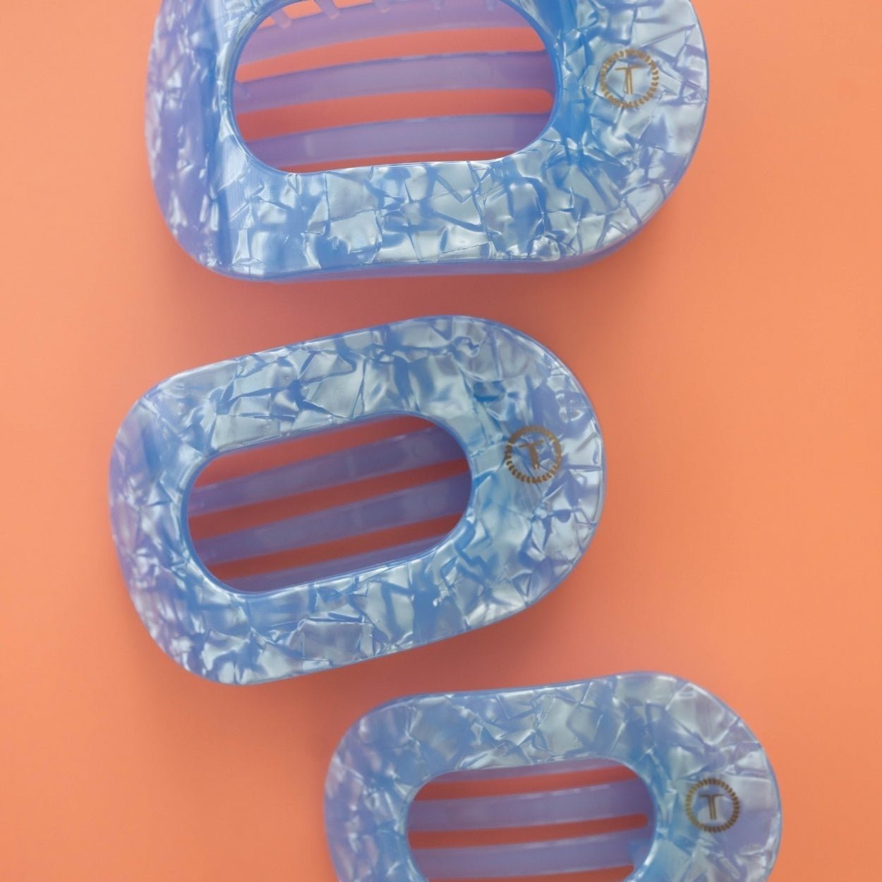Set of three light blue crinkled flat hair clips with T logo