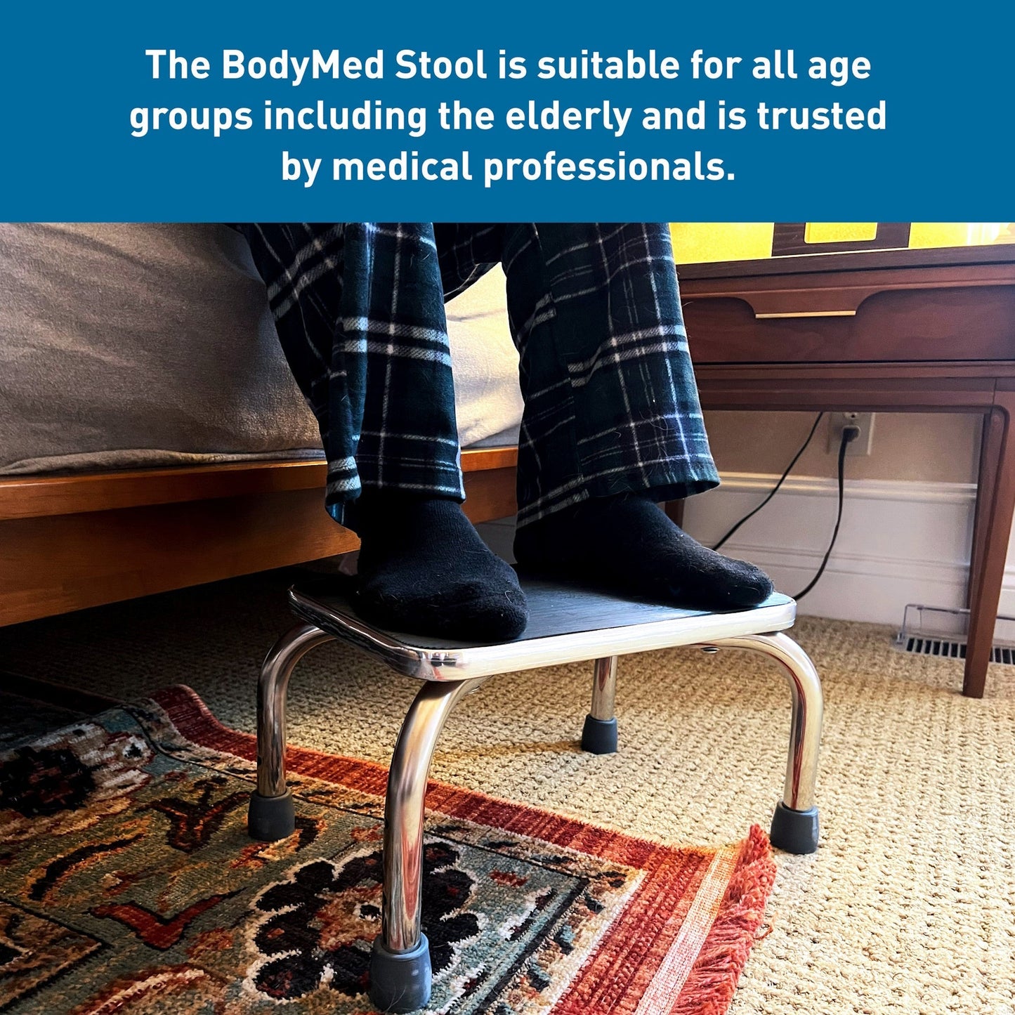Step stool with black platform and chrome legs with blue rubber tips, shown in use