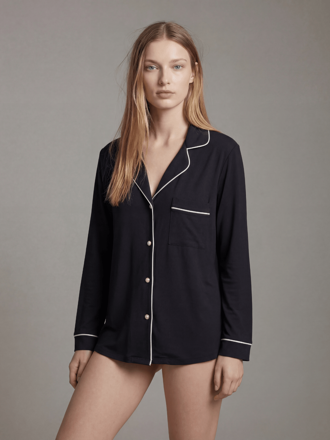 Black button-down pajama top with white piping, chest pocket, and long sleeves