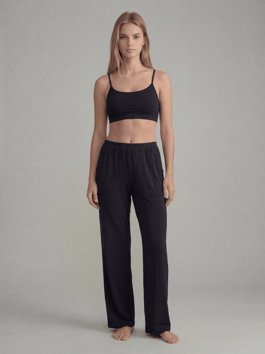 Black pajama pants with elastic waist and side pockets, wide-leg lounge fit.