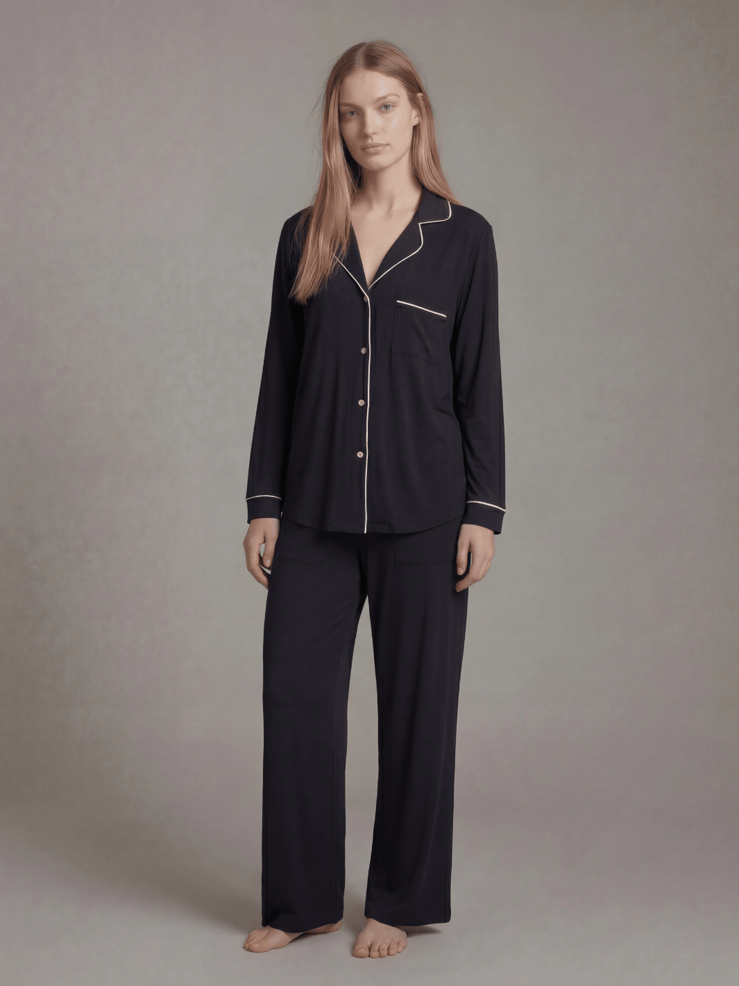 Black pajama set: long-sleeve button-down top with contrast piping and matching pants.