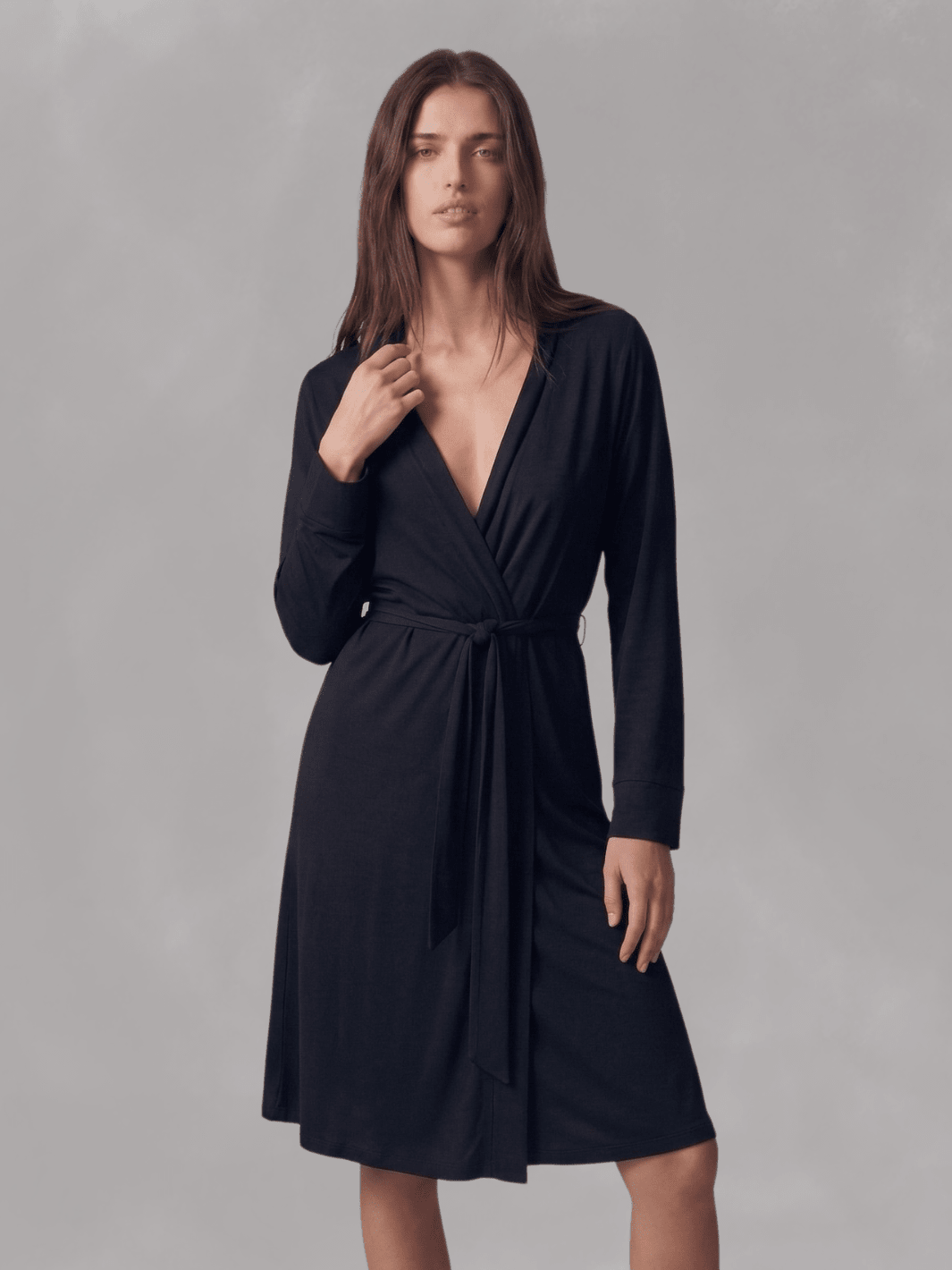 Black wrap robe with V-neck and belt tie, long sleeves, hand near neckline