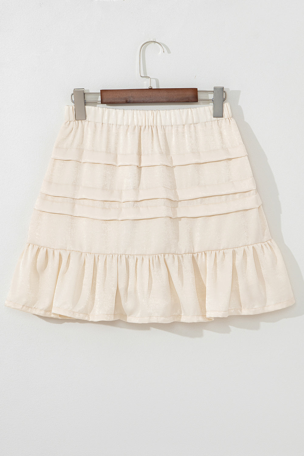 Beige tiered mini skirt with elastic waist and wide layered ruffles
