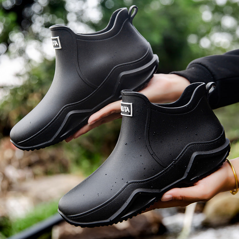 Black low-top rubber rain boots with thick tread outsole