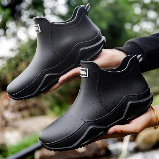 Black low-top rubber rain boots with thick tread outsole