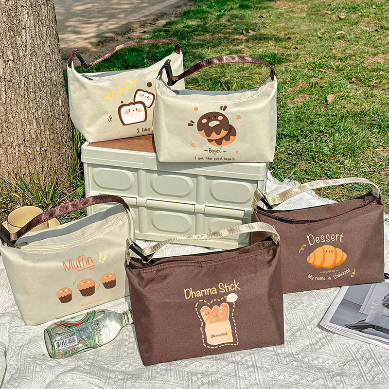 Insulated lunch bag in off-white with brown bagel cartoon graphic and handle