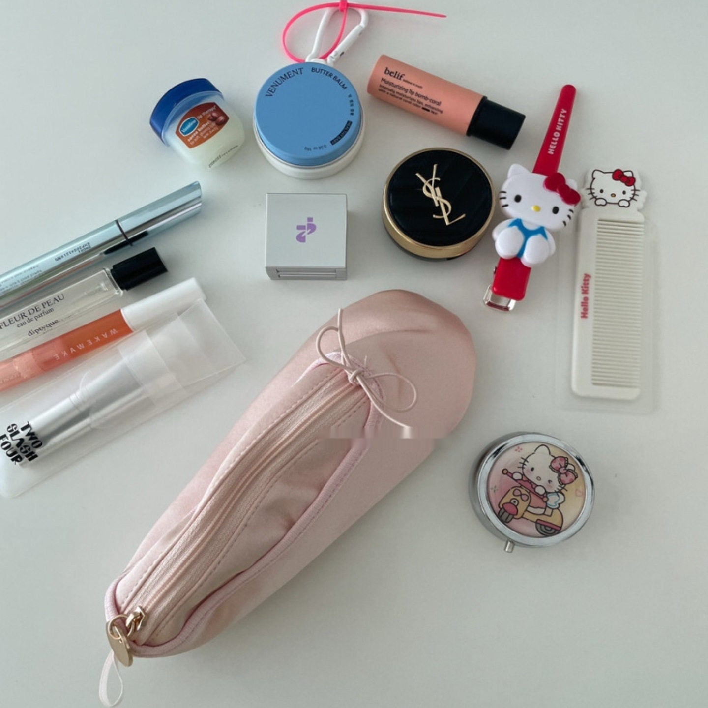 Pink ballet shoe-shaped pouch with center zipper and ribbon bow