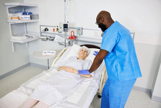 Wings premium comfort underpad on hospital bed, white absorbent sheet beneath patient
