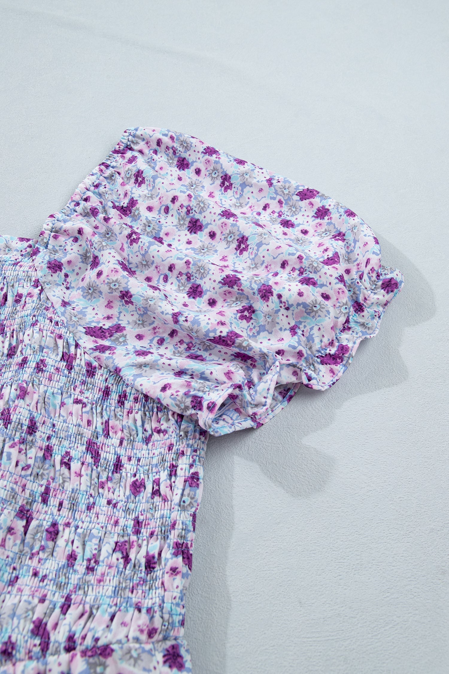 Purple floral short puff sleeve with smocked bodice on a flowing maxi dress