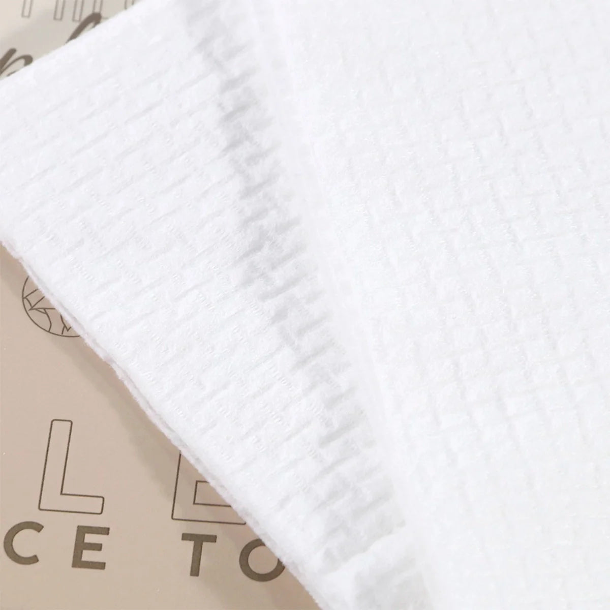Close-up of white face towel edge and embossed texture