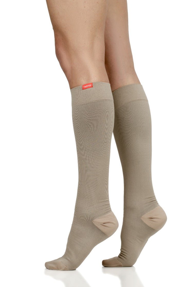 Cashew compression stockings on legs, reinforced toe and comfort band at top
