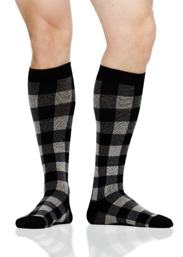 Black-and-heather gray plaid compression socks on legs, crew length