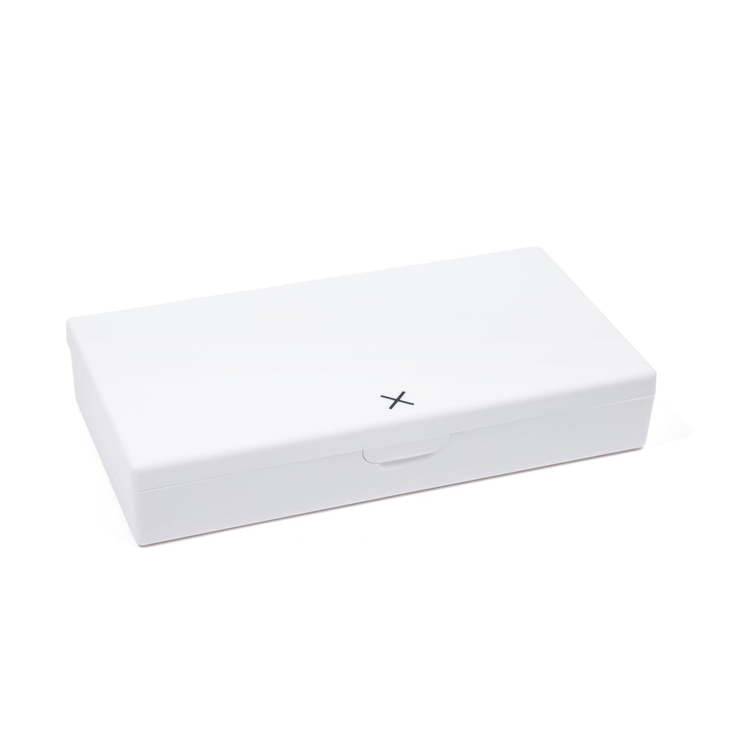 White pill box with hinged lid and X marking on the front