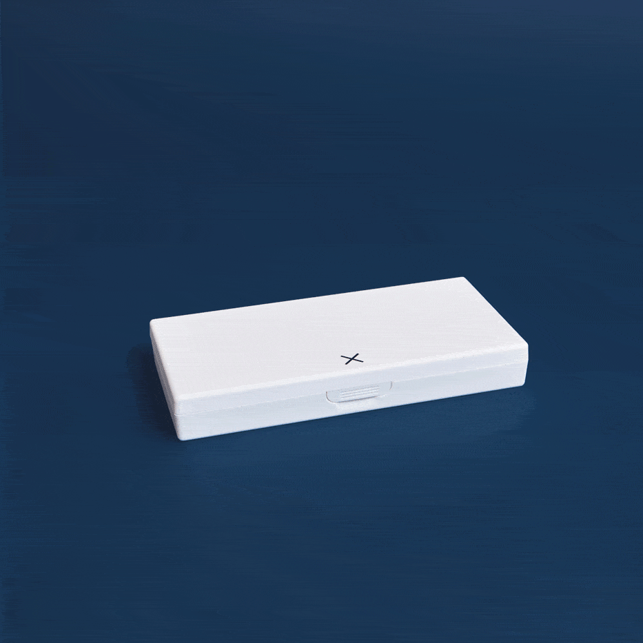 White pill box with X mark and pull-tab, lying flat