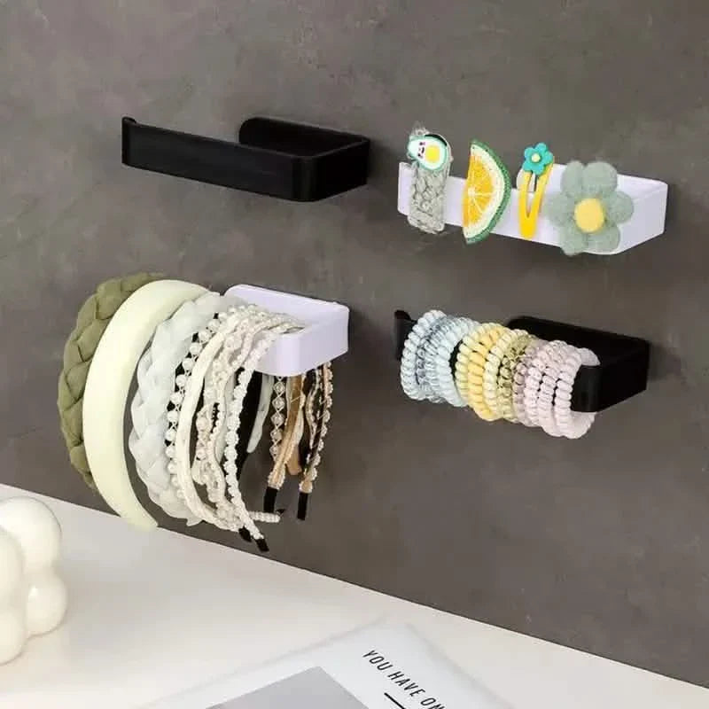 Black toilet paper holder mounted on wall holding a toilet paper roll