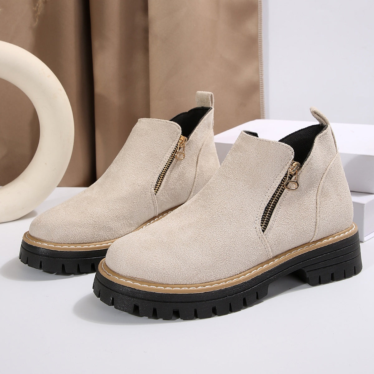 Beige suede ankle boots with side zipper and chunky black lug sole