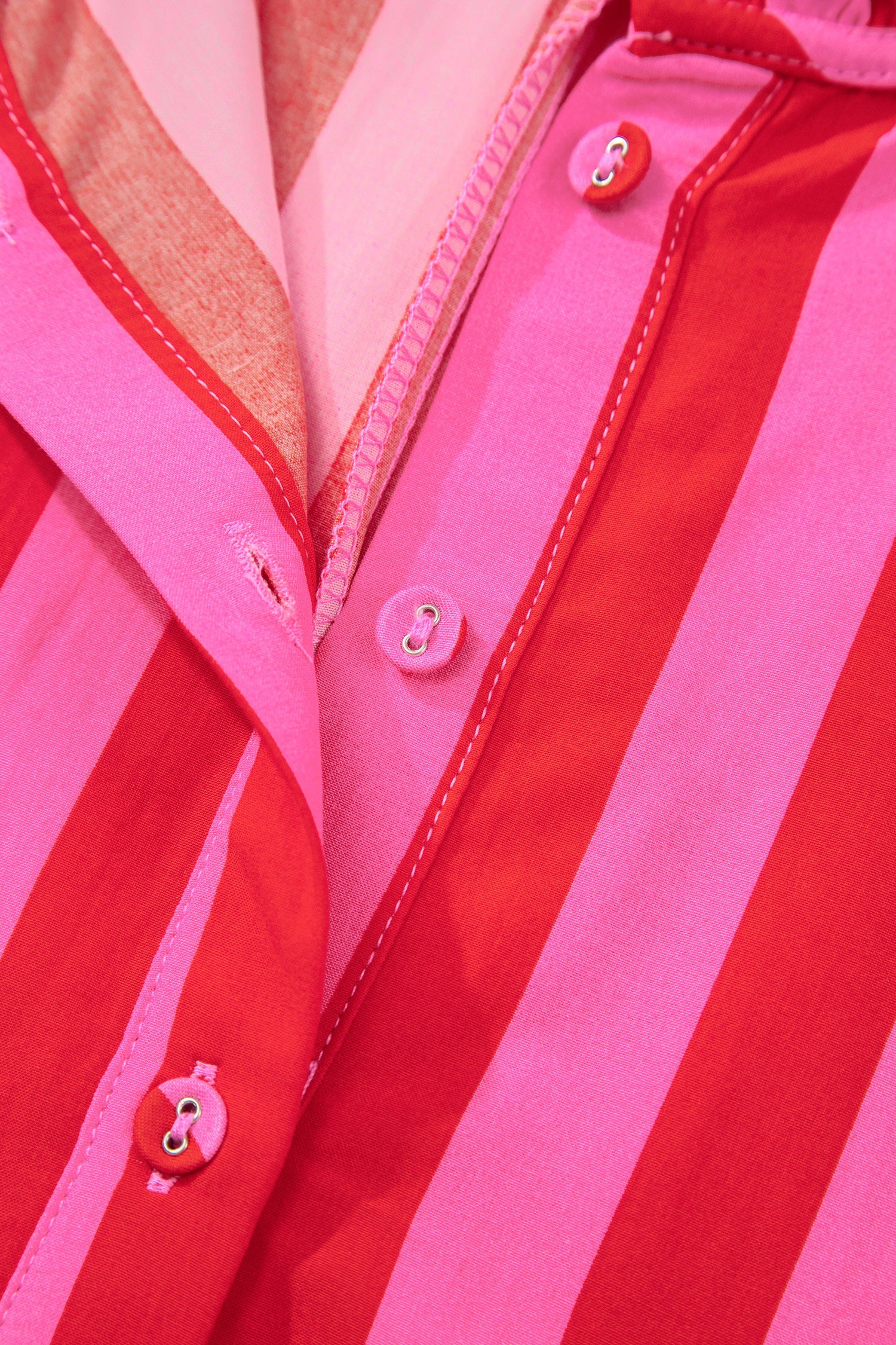 Pink and red striped dress front with pink buttons and V-neck seam