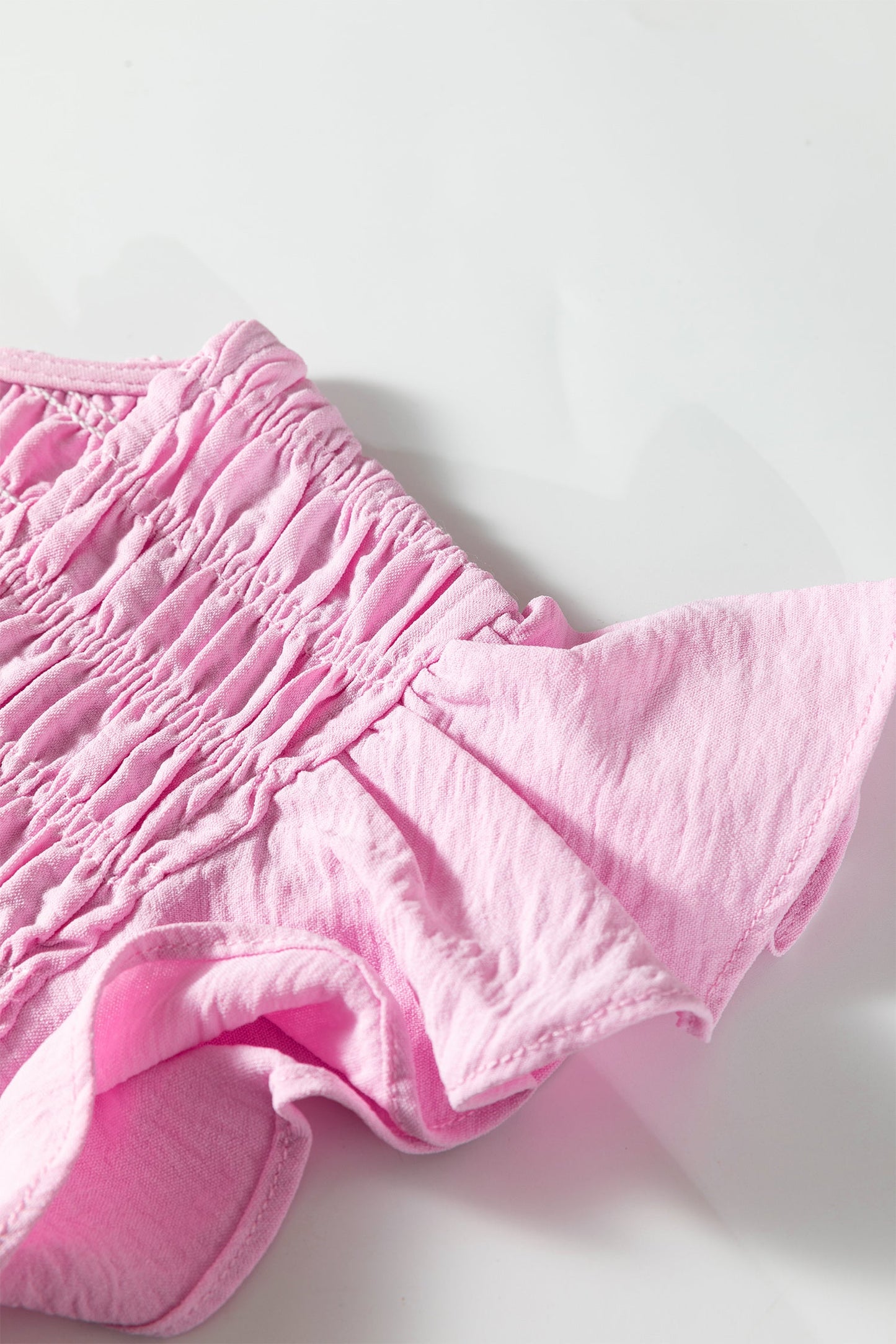 Pink smocked fabric and tiered ruffle hem detail