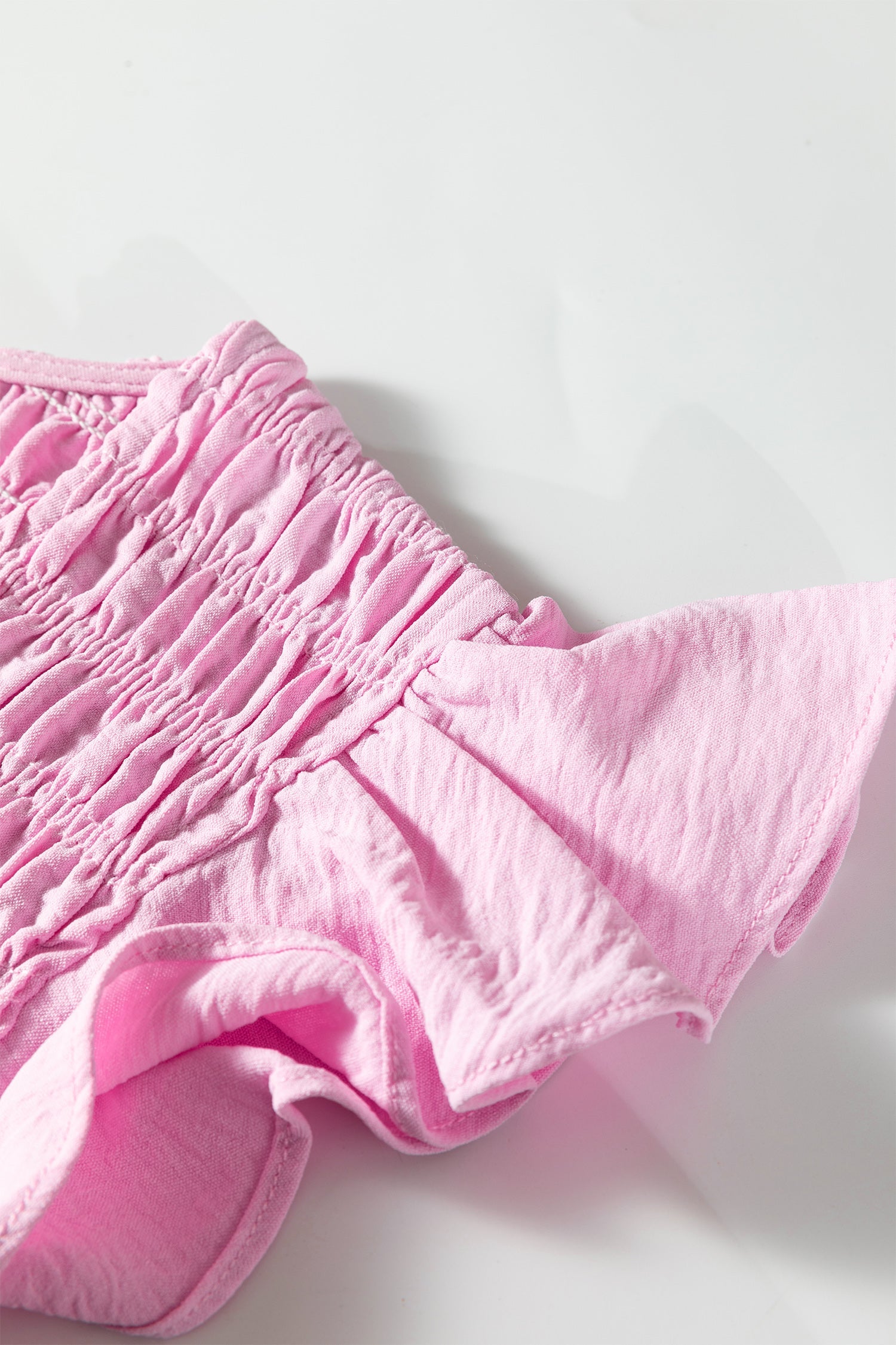 Pink smocked fabric and tiered ruffle hem detail